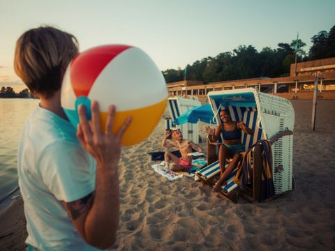 Bildvergrößerung: Titel: Kiezkampagne 2024 (Junge Leute bei Sonnenuntergang im Strandbad Wannsee)