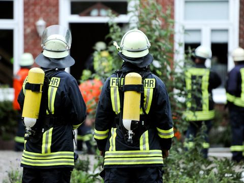 Rückenansicht von Feuerwehrmännern in Einsatzkleidung