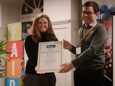 Bezirksbürgermeisterin Clara Herrmann nimmt die Urkunde zur Fairtrade-Bezirk entgegen
