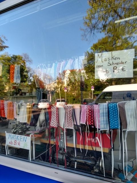 Bildvergrößerung: Viele verschiedene Mund-Nasen-Bedeckungen hängen in einem Schaufenster.