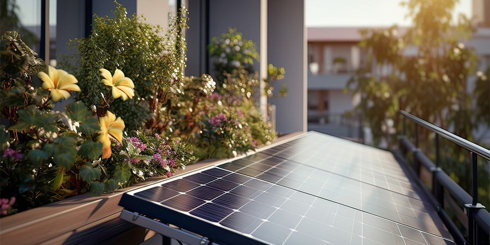 Solarmodule auf Balkon, Blumen im Hintergrund