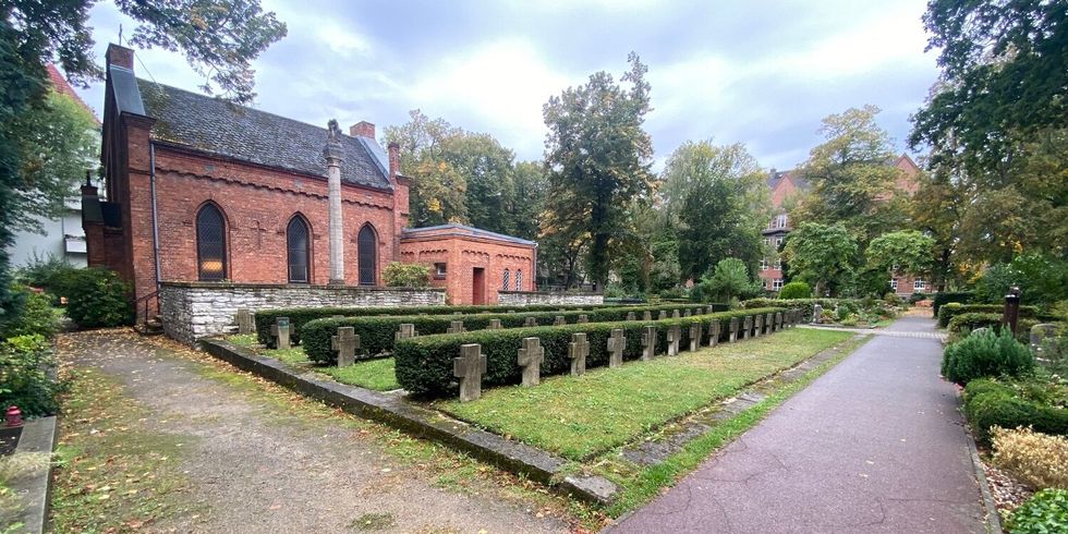 Eine Friedhof mit einer Kapelle und Kreuzen in Reihen.