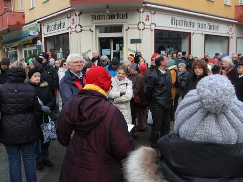 Bildvergrößerung: Menschenansammlung vor einem Eckhaus mit der Anschrift: Apotheke zum Zirkel.