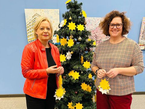 Camilla Schuler und Gesine Lötzsch vor dem Wunschbaum im Jugendamt