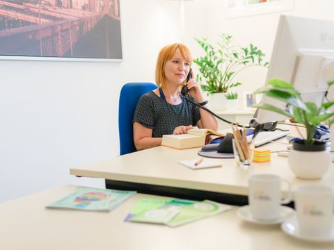 Frau telefoniert an ihrem Arbeitsplatz