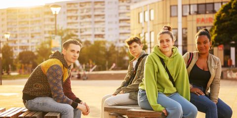 Vier junge Menschen sitzen auf einer Bank