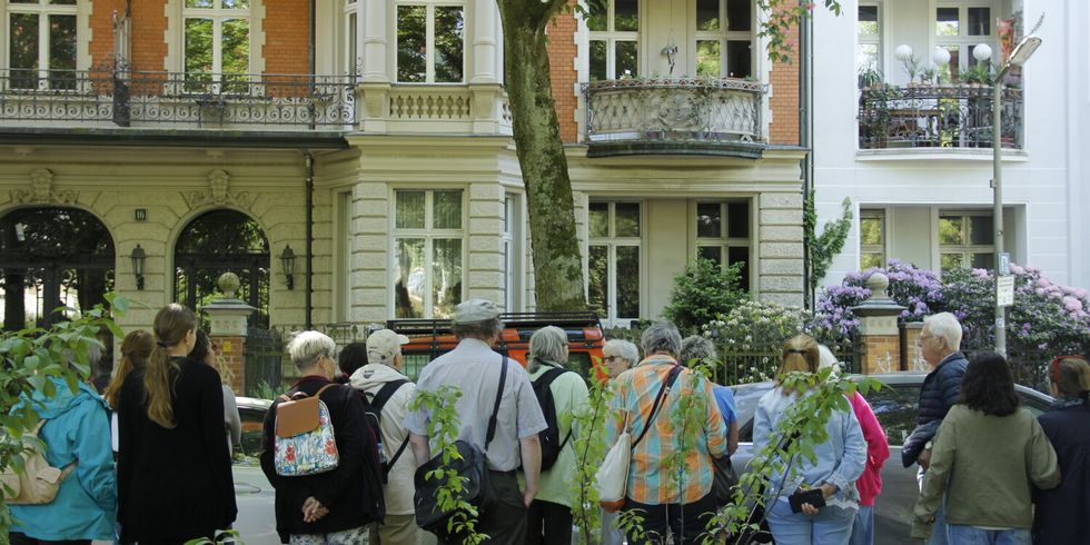 Menschen versammelt vor einem Haus