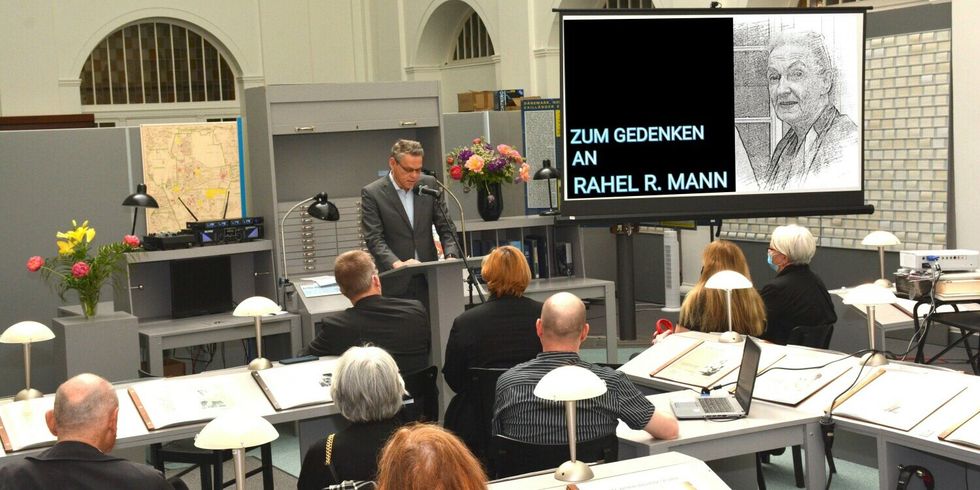 Ein Mann steht an einem Stehpult in einem Saal