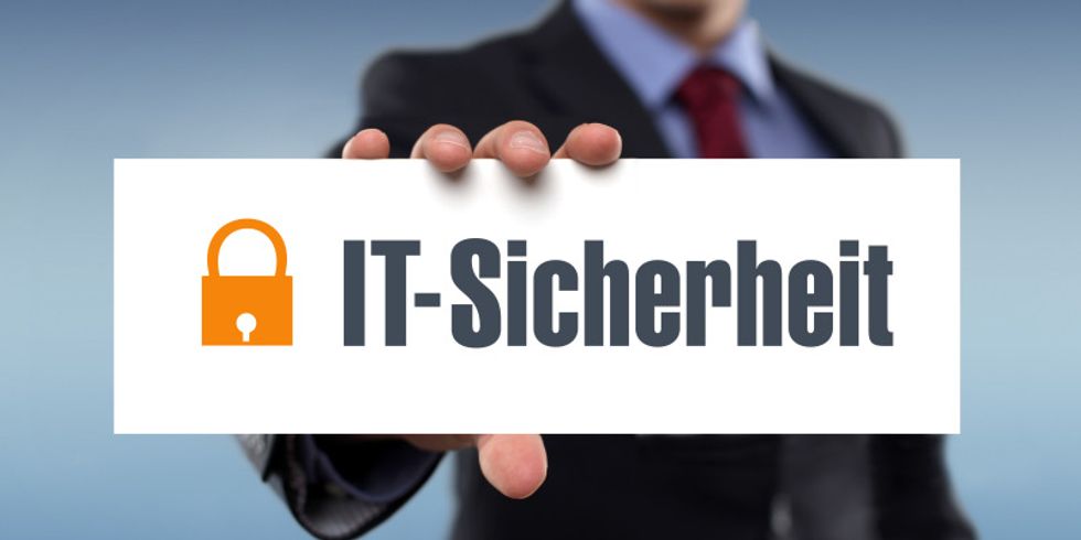 Mann hält ein Schild mit "It-Sicherheit"