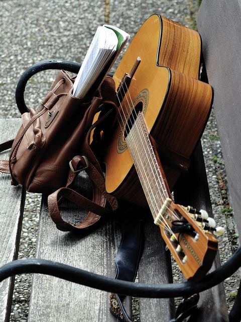 Gitarre und Rucksack auf einer Bank