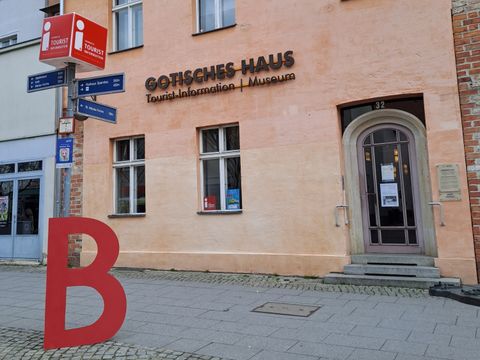 Ein großes rotes "B" steht vor dem Gotischen Haus in Spandau