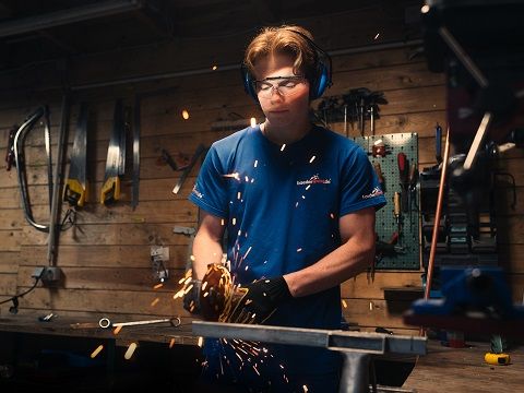 Handwerker in einer Werkstatt arbeitet mit einem Winkelschleifer.