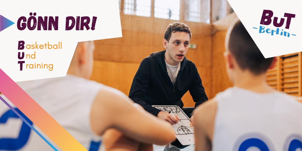 Kinder sitzen beim Basketballtraining vor ihrem Trainer