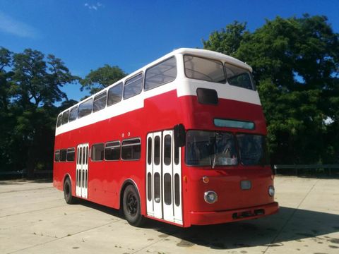 Ein roter Doppeldeckerbus steht auf einem Platz.