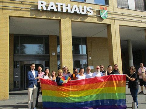 Hissen der Regenbogenfahne vor dem Rathaus 2022 - Die Teilnehmenden präsentieren die Fahne