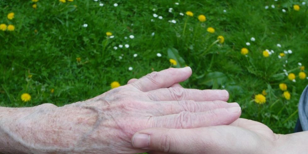 alte und junge Hand berühren sich