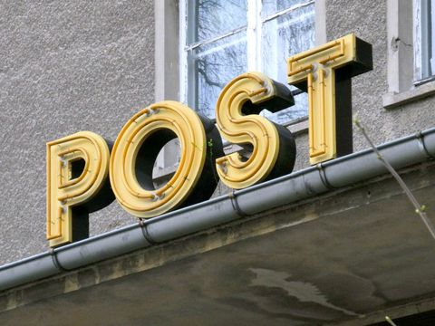 Eine Postleuchtschrift über einem Eingang