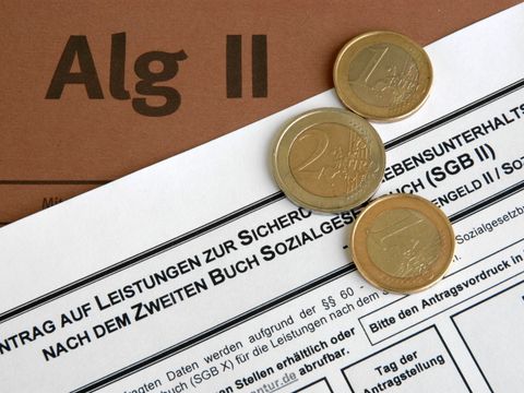 Euro-Münzen liegen auf einem Alg-II-Antrag