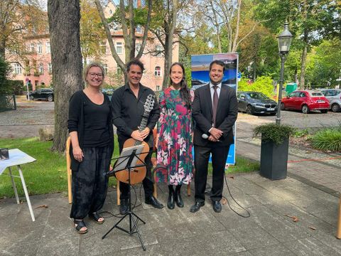 23.08.2022: Argentinien-BBQ im Garten des Kommunikationszentrums am Ostpreußendamm (v.l.n.r.: Freizeitstättenleiterin Stefanie Müller, Federico D'Atellis/Gitarre, Nacha Daraio/Gesang, Botschaftssekretär Martín Castro)