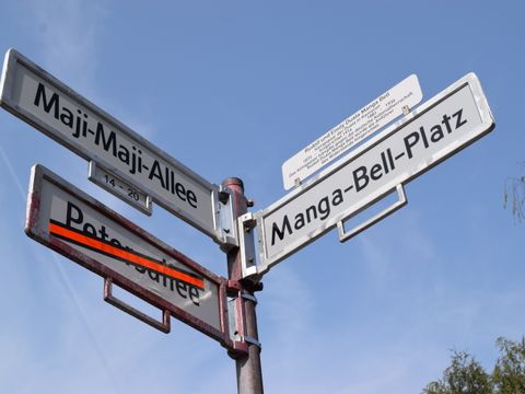 Straßenschild an der Kreuzung Manga-Bell-Platz und Maji-Maji-Allee mit der durchgestrichenen Petersallee