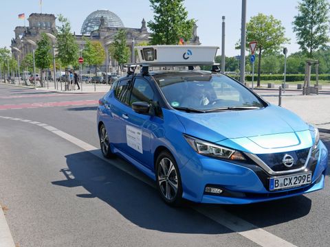 Ein blaues Auto ist als Scan-Fahrzeug auf den Straßen Berlins unterwegs. Mit einer auf dem Dach montierten Kamera werden so Daten erfasst.