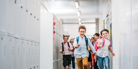 Schülerinnen und Schüler rennen über den Schulflur