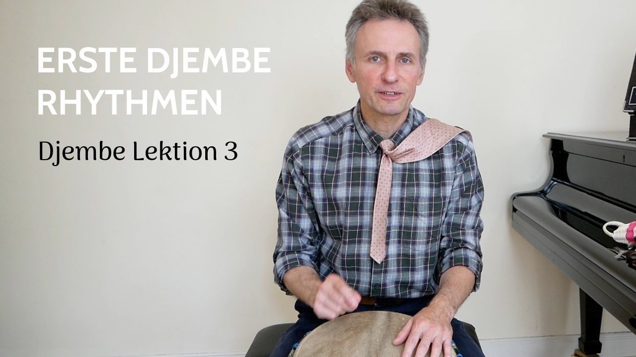 Mann sitzt vor Djembe