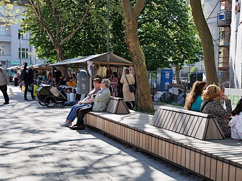 Platz mit langer Bank und Marktständen