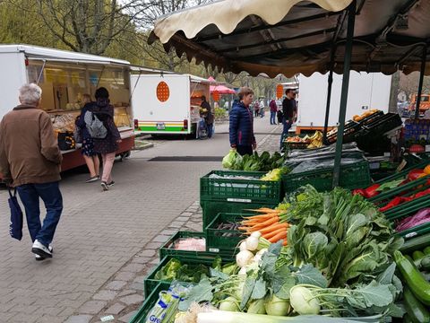 Wochenmarkt Parchimer Allee mit Gemüse im Vordergrund und Besuchern im Hintergrund