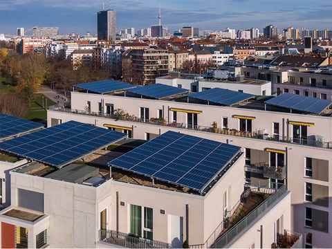 Mehrfamilienhäuser Möckernkiez mit Solaranlagen auf dem Dach. Im Hintergrund die Stadt Berlin.