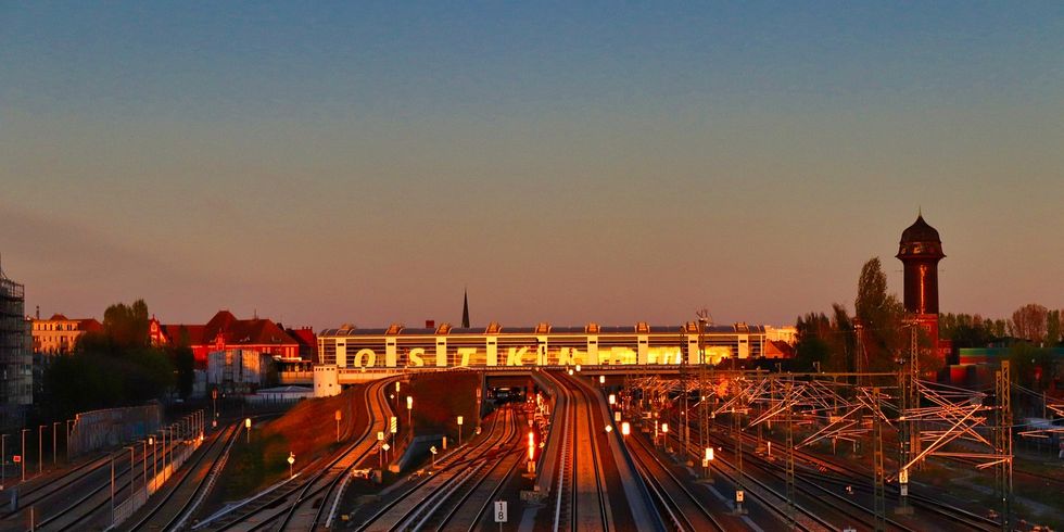 Bild von Bahngleisen und dem Bahnhof Ostkreuz in der Abendsonne