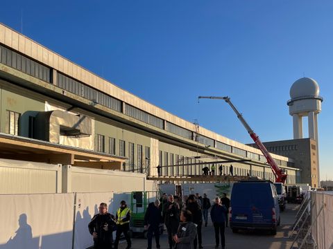 Eine Gruppe Menschen vor den Hangars auf dem Tempelhofer Feld