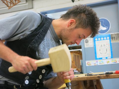 Berufsschüler bearbeitet Holz