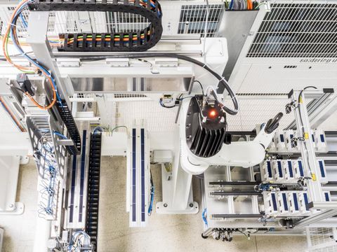 Anlage für die Verschaltung von Matrix-Schindelmodulen entwickelt. Ein Roboterarm ordnet die Schindelzellen in einer Matrix an und bereitet sie für den Klebeprozess vor.