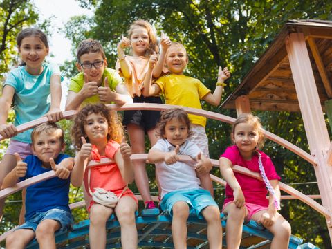 The little kids in the playground are showing thumbs up