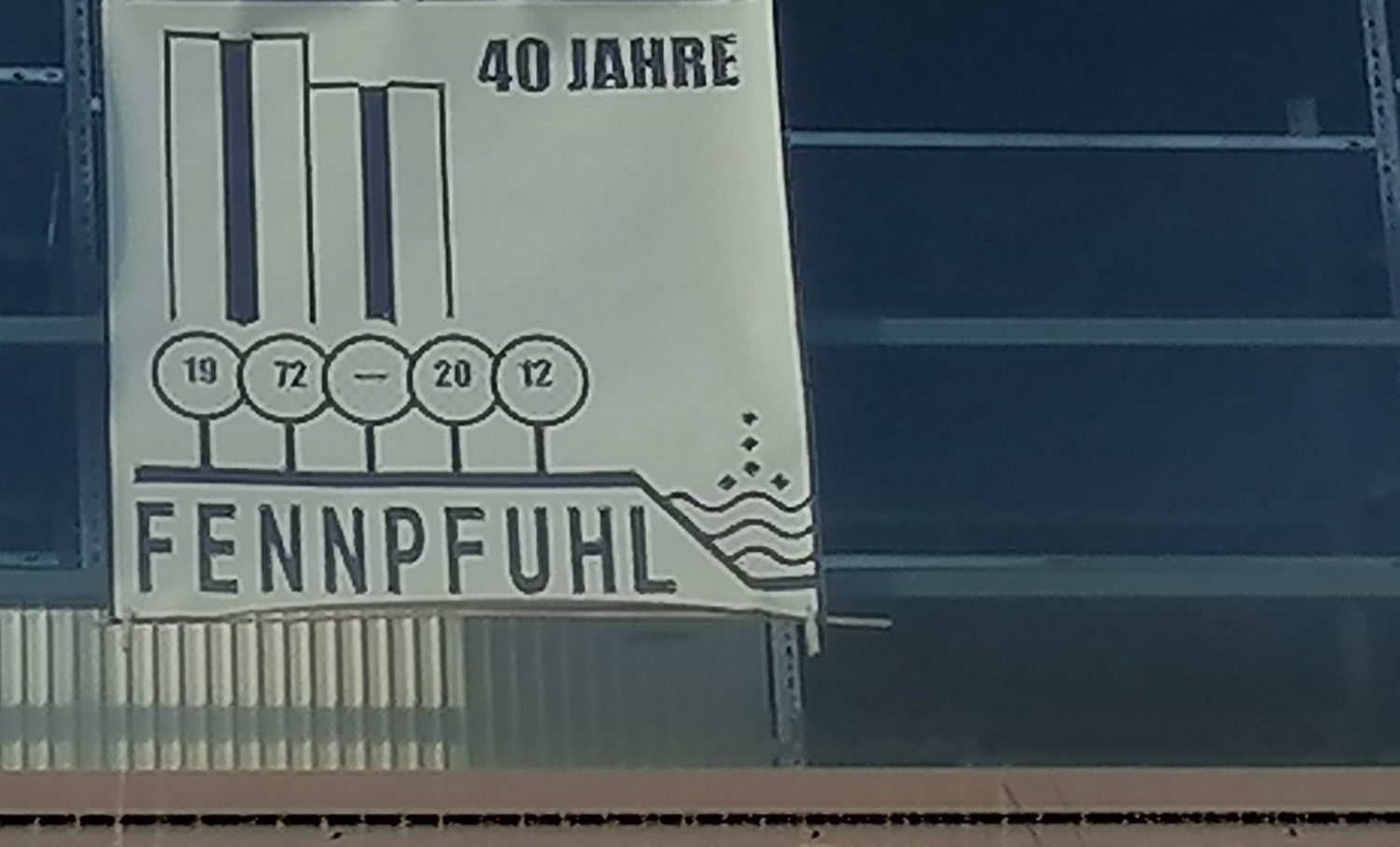 Plakat "40 Jahre Fennpfuhl" an einem Fenster am Anton-Saefkow-Platz in Berlin-Lichtenberg