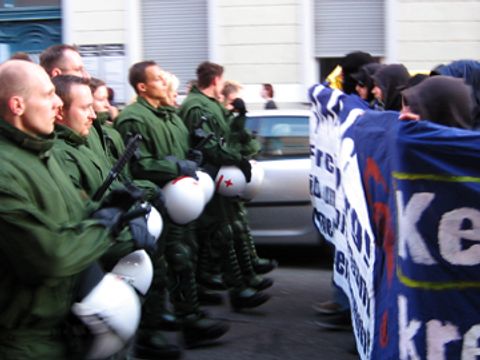 buehne_Eine Gruppe von Polizisten kämpfen auf einer Straße gegen eine Gruppe Demonstranten an