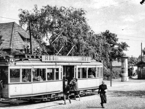 Historische Aufnahme von der Straßenbahnhaltestelle der Linie 47 in Rudow mit ein- und aussteigenden Passagier*innen