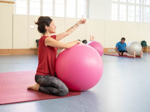 Frau sitzt an Gymnastikball