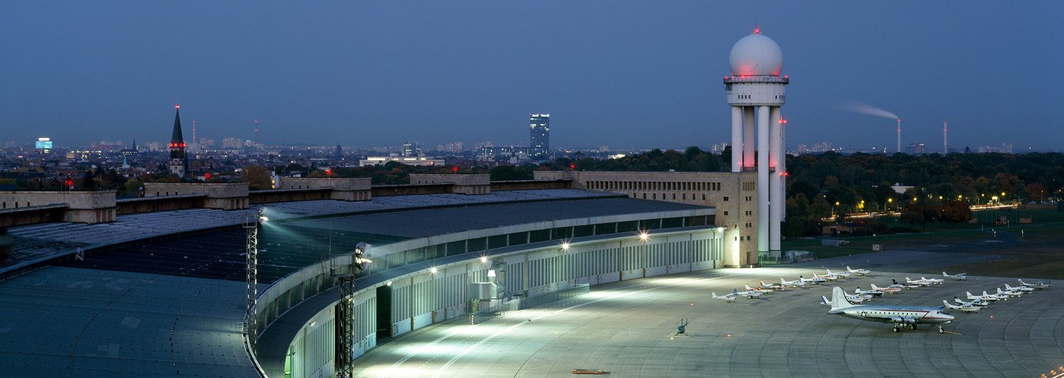 Bildvergrößerung: Beleuchtetes Flughafenfeld und Flughafentower bei klarem Nachthimmel