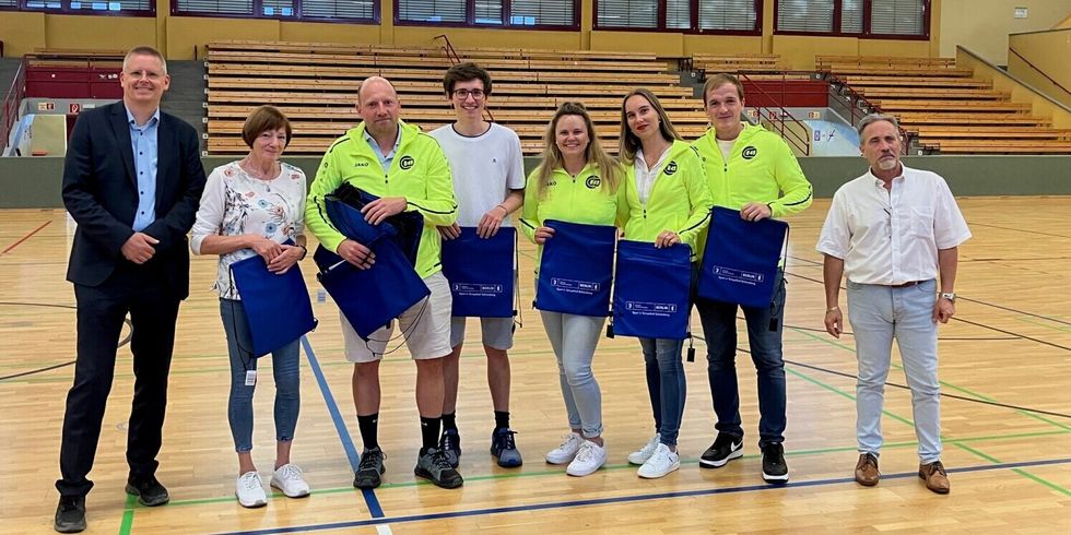 Gruppenbild mit 8 Personen in einer Sporthalle