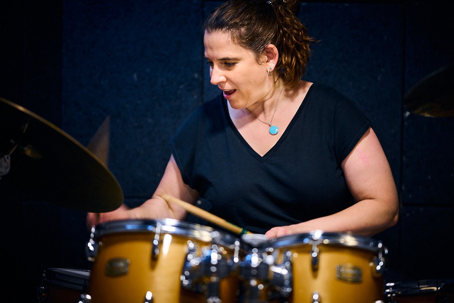 Portrait der Kursleiterin Claudia Hoppe die am Schlagzeug trommelt