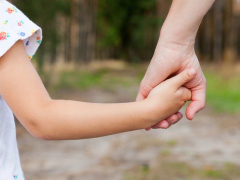 Mutter hält die Hand ihres Kindes