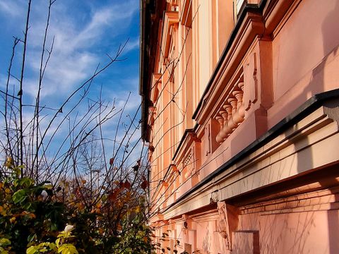 Rosa Fassade eines historischen Bauerhauses in Alt-Friedrichsfelde