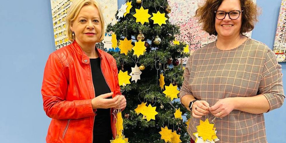 Camilla Schuler und Gesine Lötzsch vor dem Wunschbaum im Jugendamt