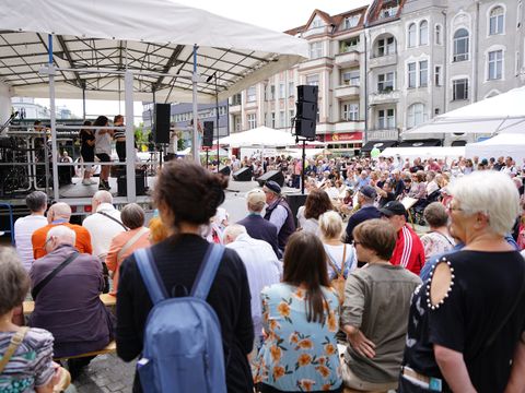 Zahlreiche Besucher_innen genießen den Sonntagnachmittag und lauschen den musikalischen Darbietungen.