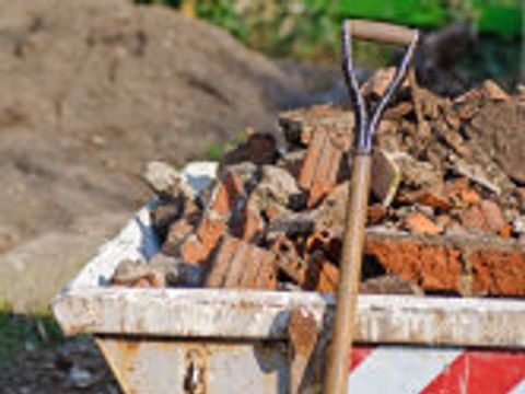 Schaufel und Bauabfälle auf einer Baustelle