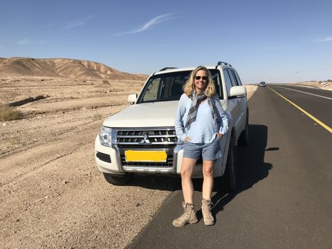 Nicola Albrecht vor Auto auf Straße in Wüste
