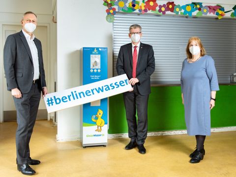 Bildvergrößerung: Wasserbetriebe-Finanzvorstand Frank Bruckmann, Bezirksbürgermeister Helmut Kleebank und Sabine Adelhoefer, Schulleiterin der Grundschule am Weinmeisterhorn nahmen gemeinsam den neuen Wasserspender in Betrieb