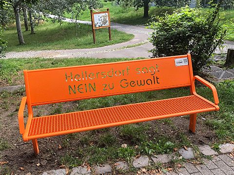 Orangene Bank im Park mit der Aufschrift "Hellersdorf sagt Nein zu Gewalt"